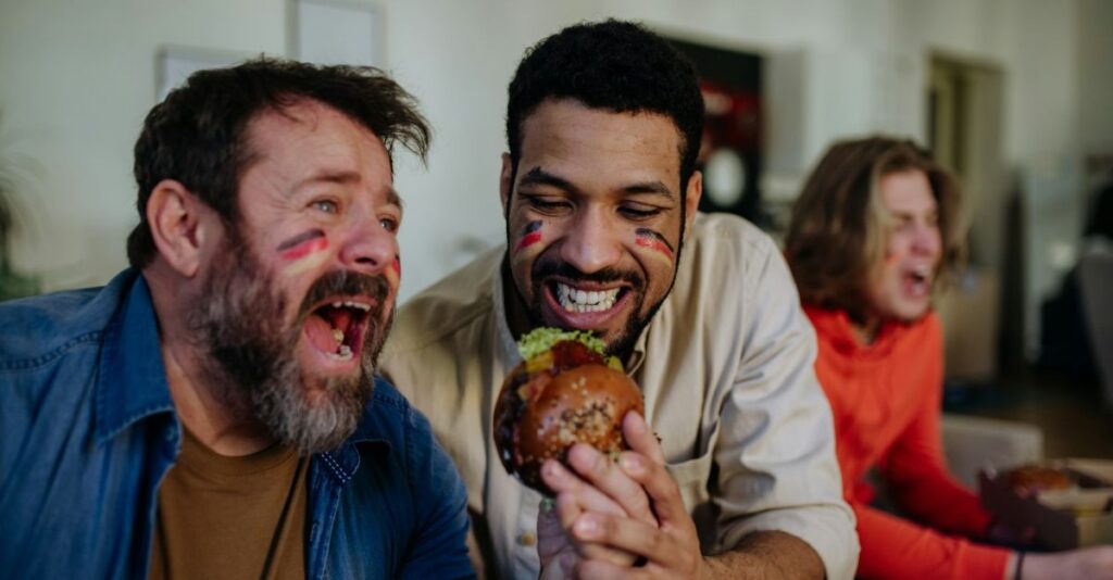 Aficionados comiendo hamburguesa