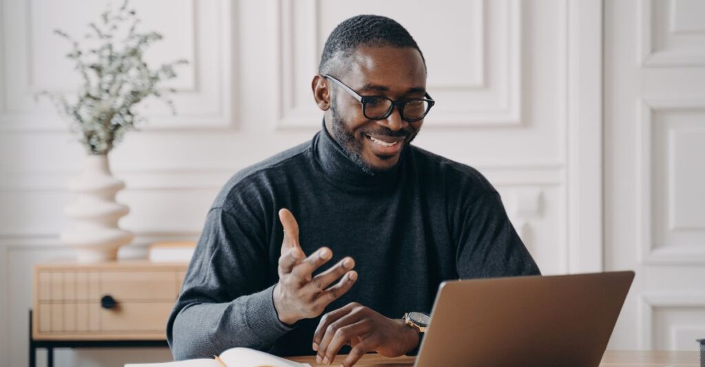 Hombre hablando frente a computadora portátil