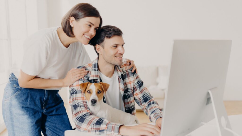 Pareja feliz frente a una computadora buscando palabra clave